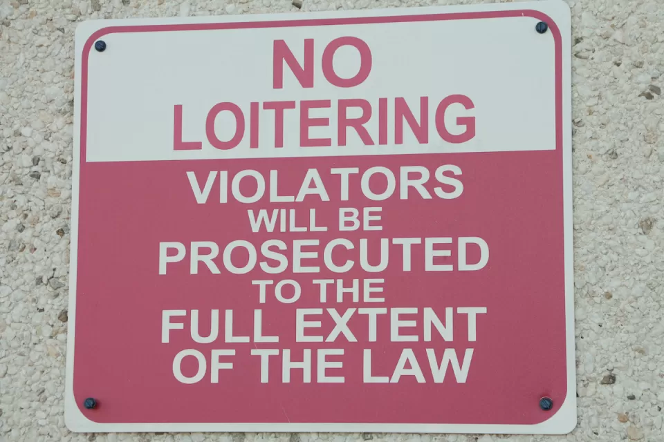 Red and white "No Loitering" sign.